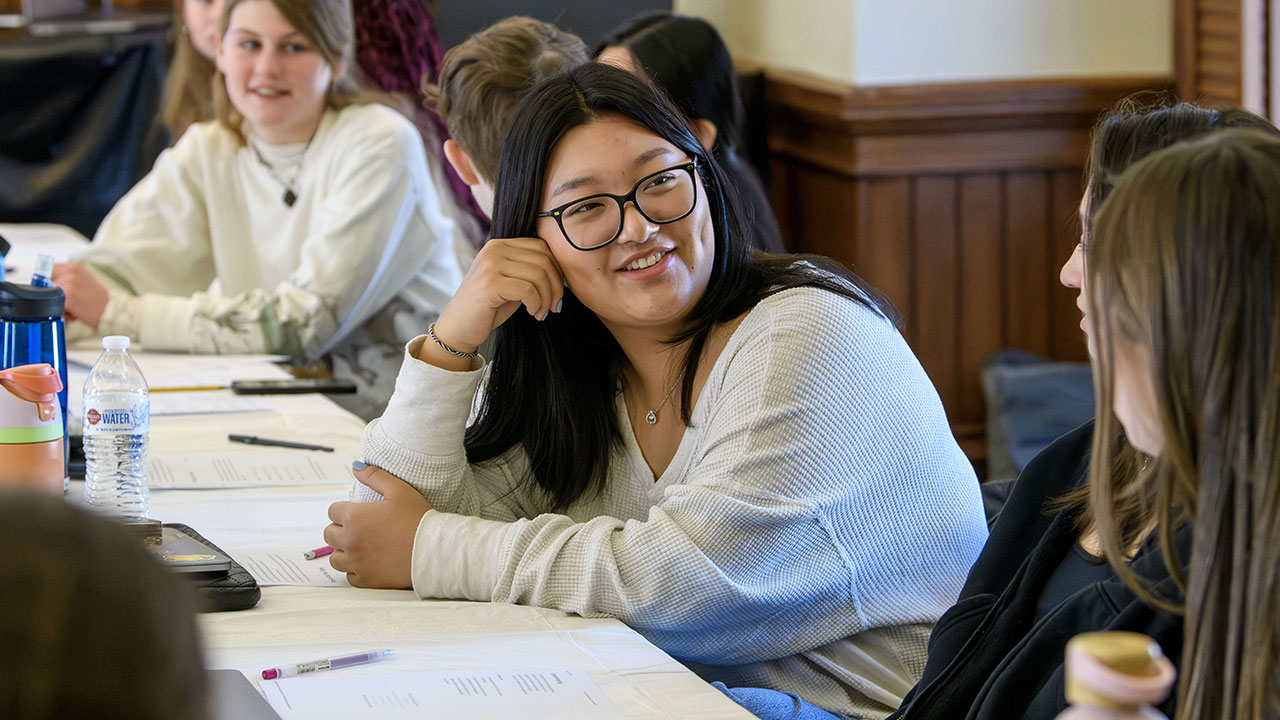 Students in the Weiss Women program talk about leadership at a table.